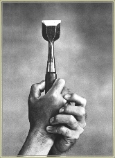 Hands holding a chisel used in piano making
